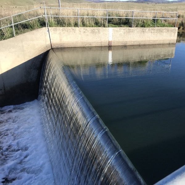 Water flowing over a concrete measurement weir