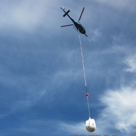 Helicopter carrying a sling load to a remote site